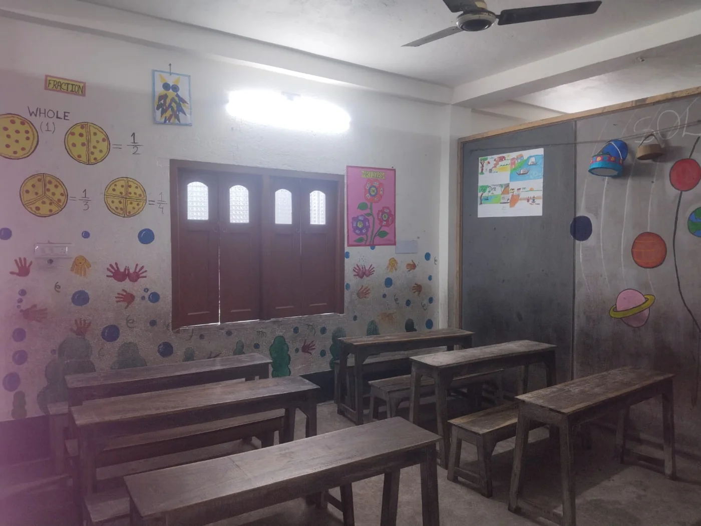 A classroom with benches and colourful wall decorations